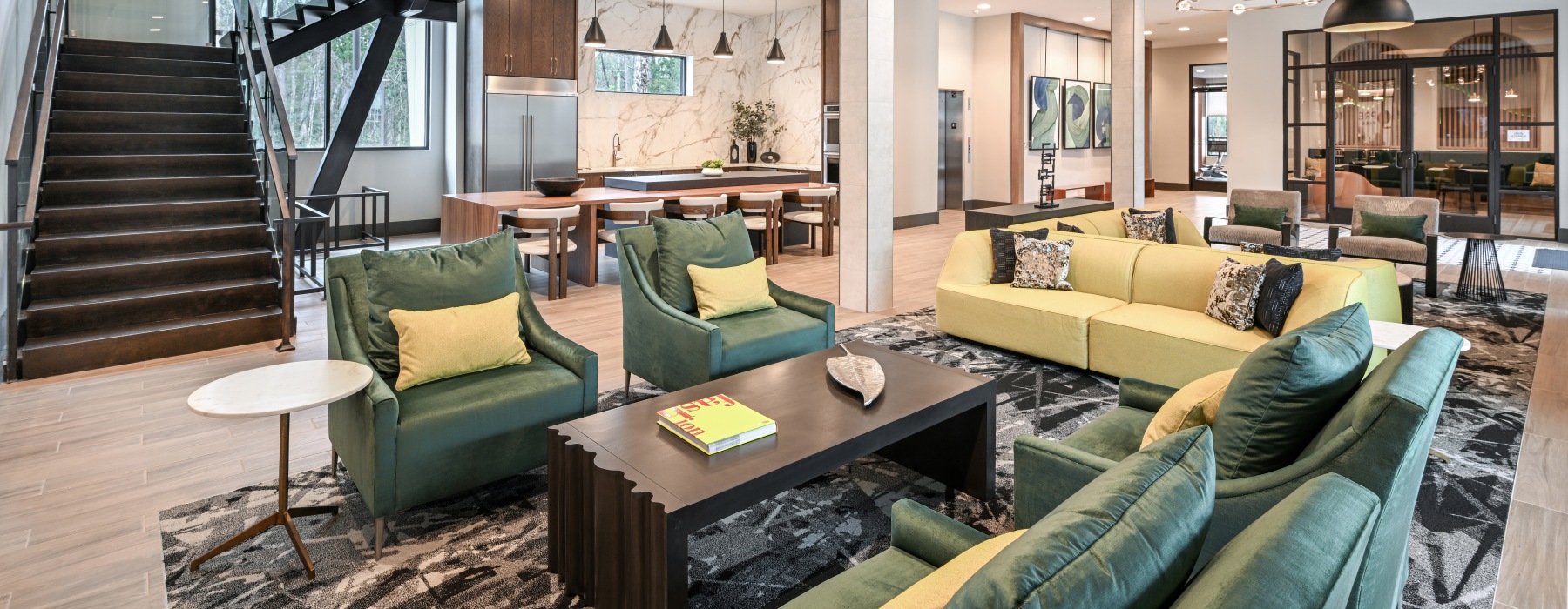Modern clubroom at Haven 8181 with lounge seating, staircase, and open resident gathering space